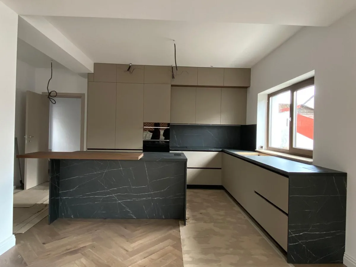 Bucătărie greige cu insulă de nuc și marmură Nero Marquina
