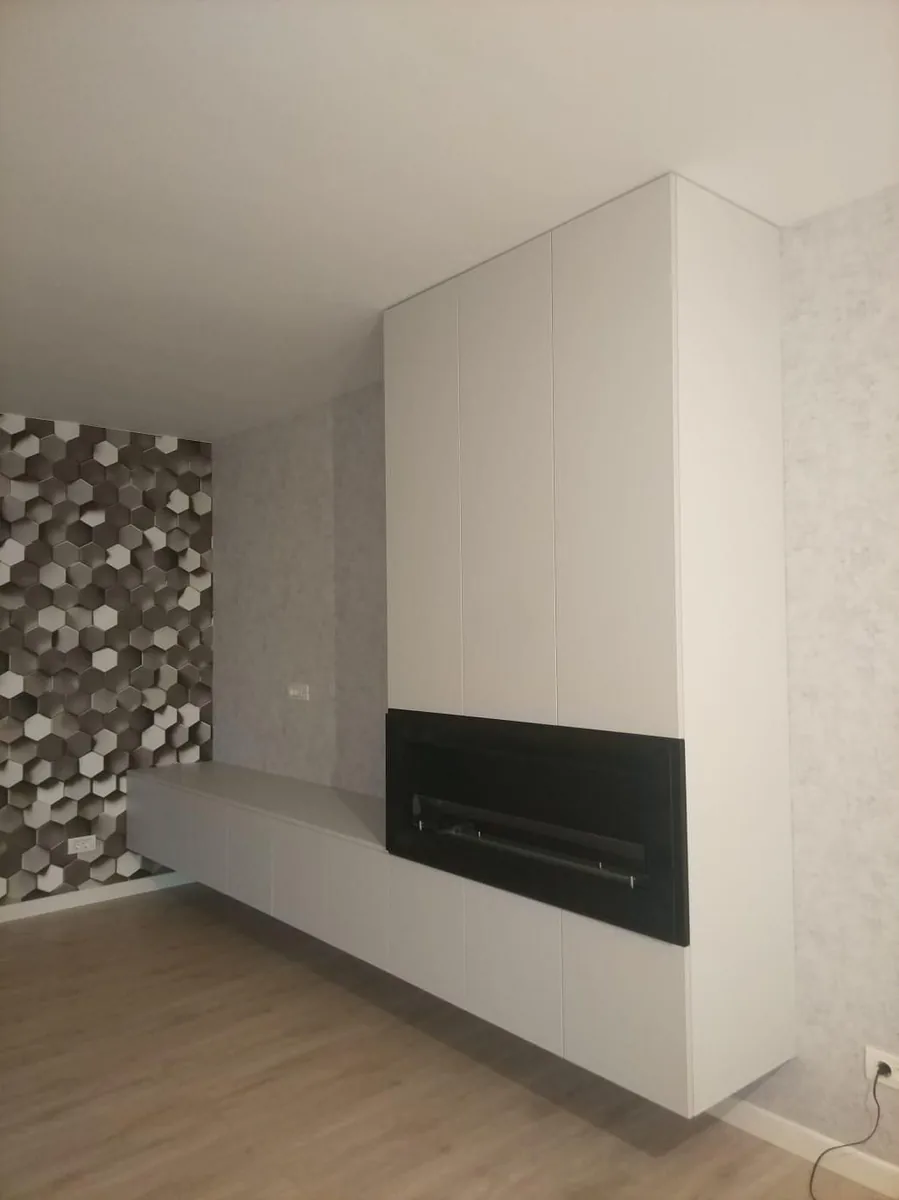 Living cu comodă albă și șemineu electric